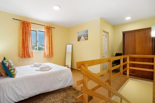 um quarto com uma cama e um armário de madeira em São Vicente House em São Vicente