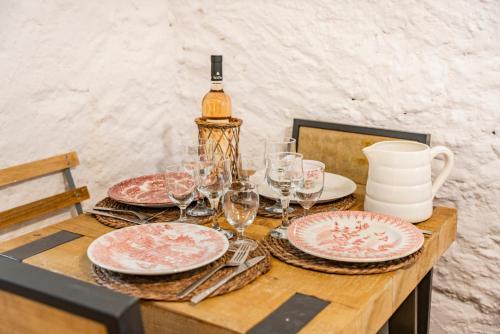 a table with plates and a bottle of wine at La Maison de l'Âne in Seillans
