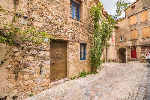 an alley in an old stone building with a wooden door at La Maison de l'Âne in Seillans