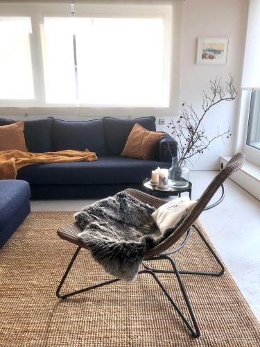 uma sala de estar com uma cadeira e um sofá em großzügiges Penthouse-Loft - modern möbliert mit Einbauküche in zentraler und ruhiger Lage em Bad Vilbel