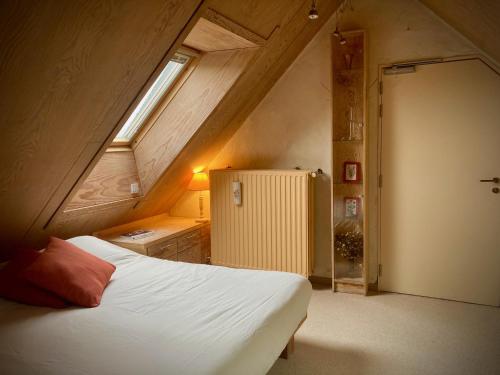 Oosterzele的住宿－De Keukentafel B&B，一间卧室,在阁楼上设有床和窗户