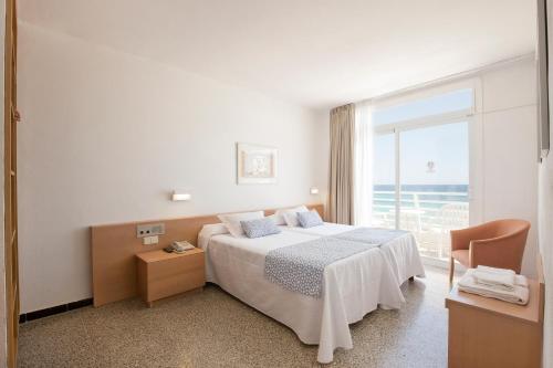 Habitación de hotel con cama y ventana grande en Hotel Sultán, en Can Picafort