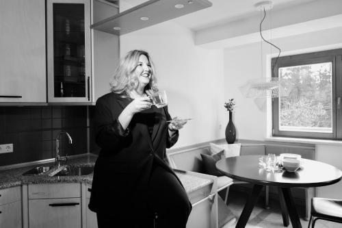una mujer parada en una cocina sosteniendo una copa de vino en Freien Living Angerberg, en Angerberg