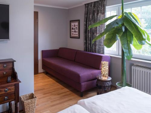 a living room with a purple couch and a window at Schloss Hertefeld & Hertefeldhof in Weeze
