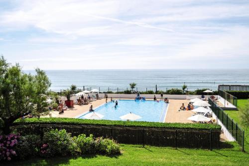 a view of a swimming pool with the ocean in the background at Belambra Clubs Anglet - La Chambre d'Amour in Anglet