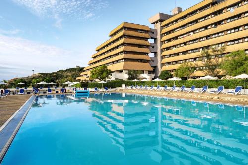 a swimming pool with chairs and a building at Belambra Clubs Anglet - La Chambre d'Amour in Anglet