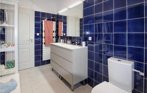 bagno piastrellato blu con lavandino e servizi igienici di Beautiful Home In Villeneuve Les Avignon With Kitchen a Villeneuve-lès-Avignon