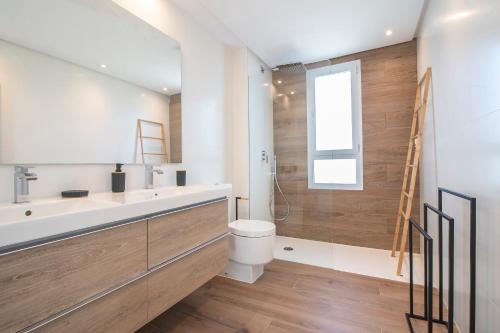 een badkamer met een wastafel, een toilet en een douche bij Halo - Deluxe Apartment With Terrace Steps From The Beach in Sotogrande