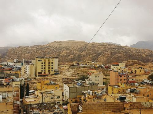 uma cidade com edifícios e uma montanha ao fundo em Jordanian Baity Apartment em Wadi Musa