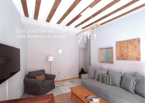 sala de estar con sofá y TV en Boutike Apartments, en Sevilla
