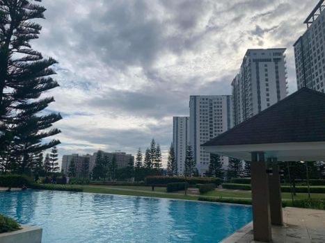 a large swimming pool in a city with tall buildings at Suēlo at Cool Suites at Wind Residences Tagaytay in Tagaytay