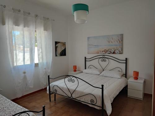 een slaapkamer met een zwart-wit bed en een raam bij Casa Limone in San Pietro in Bevagna