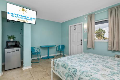 a bedroom with a bed and a sign for a vacation resort at Latitude 26 Waterfront Resort and Marina in Fort Myers Beach