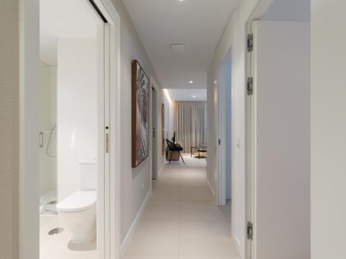 a hallway leading to a bathroom with white walls at Royal Suites in Las Palmas de Gran Canaria