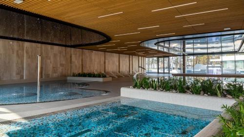 un vestíbulo con una gran piscina en un edificio en AXEL WAVE Seaview Apartment &SPA, en Międzyzdroje