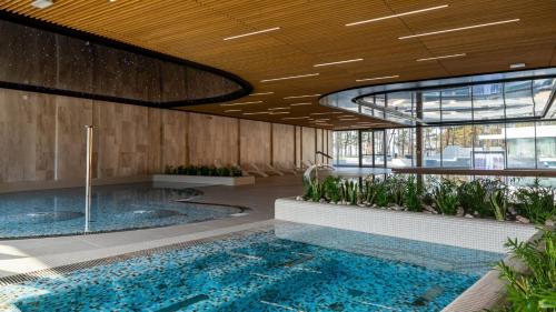 a lobby with a large pool in a building at AXEL WAVE Seaview Apartment &SPA in Międzyzdroje