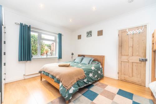 a bedroom with a bed and a window at 6 bedrooms beautiful home 3 bathrooms, quiet location with garden near Legoland Windsor Heathrow in Maidenhead