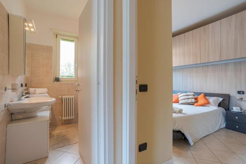 Lake Como Apartment with Balcony and Private Parking في Ossuccio: حمام مع سرير ومغسلة في الغرفة