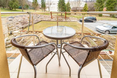 a table and two chairs on a balcony at Penzión Zunama in Bardejovské Kúpele