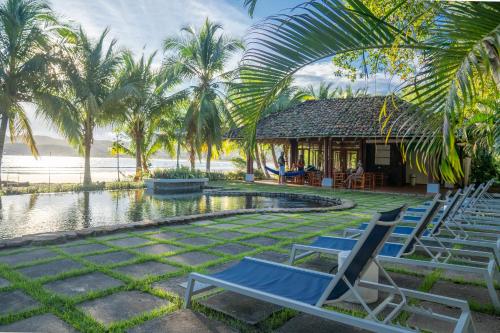 a group of chairs sitting next to a swimming pool at Villa Marina Lodge & Condos in Playa Venao