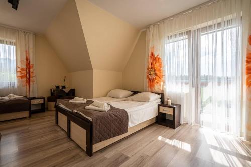 a bedroom with a bed and a large window at Budzowy Dworek in Murzasichle