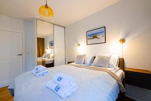 - une chambre avec un lit et des serviettes dans l'établissement Aura 40 by Q4Apartments, à Gdańsk