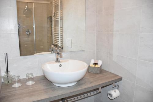 a white bathroom with a sink and a mirror at R & A Minerva Suites in Pavia