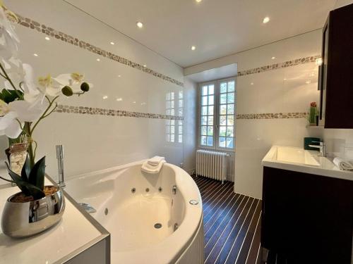 Baño blanco con bañera y lavamanos en Le domaine de Jade, en Châtillon-la-Borde