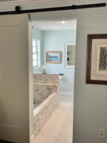 a door leading into a room with a brick fireplace at Turtle Island - Family Friendly Pool Home -Welcome in Naples