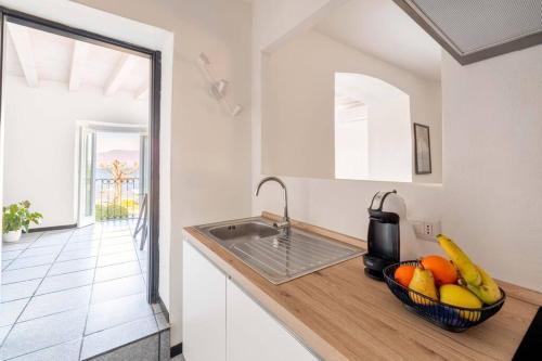 a kitchen with a bowl of fruit on a counter at INCANTO Splendida vista lago in pieno centro in Lesa