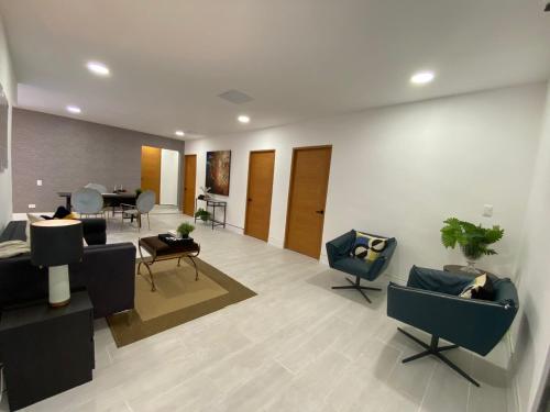 a living room with couches and chairs and a table at Suites By SalcedO in Santo Domingo