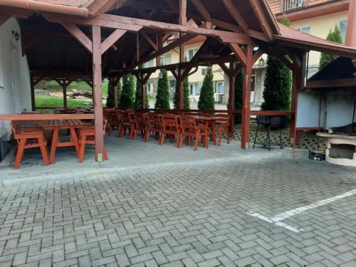 a group of wooden tables and chairs under a pavilion at Villa Prestige in Sovata
