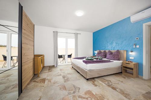 1 dormitorio con cama y pared azul en Villa Nur Pula, en Pula