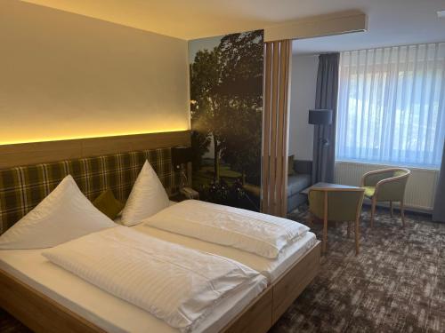 una camera d'albergo con letto e tavolo di Landhotel Flöhatal a Heidersdorf