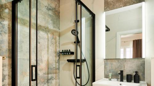 een douche in de badkamer met een wastafel en een spiegel bij Villa AdriaStar in Dugi Rat