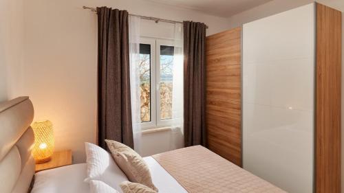 een slaapkamer met een wit bed en een raam bij Villa AdriaStar in Dugi Rat