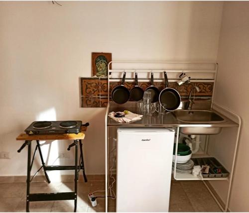 a kitchen with a sink and a counter with pots and pans at Cara Casa al Porto n.25 in Bari