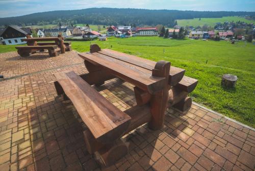 a wooden picnic table sitting on a brick patio at Aparthotel Teddy Kvilda in Kvilda