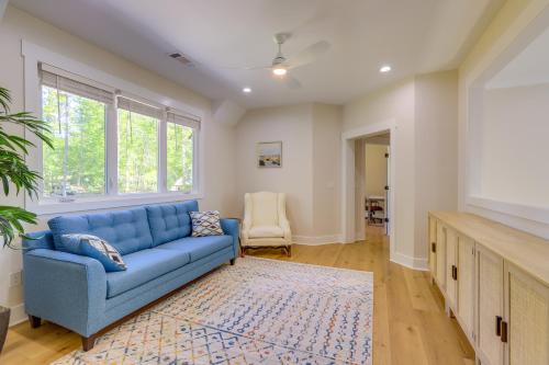 a living room with a blue couch and a tv at Spacious Lake Sinclair Vacation Rental with Dock! in Resseaus Crossroads