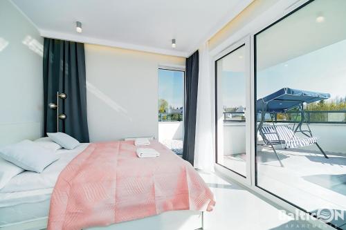 コウォブジェクにあるApartamenty BalticON Westin House -luksusowy 70m2 , basen pool, sauna, parking inklusiveのベッドルーム1室(ベッド1台付)、バルコニー(ピアノ付)