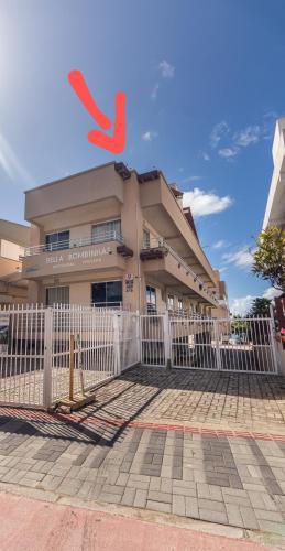 a building with a white fence in front of it at Pousada Bella Bombinhas - Pé na areia in Bombinhas