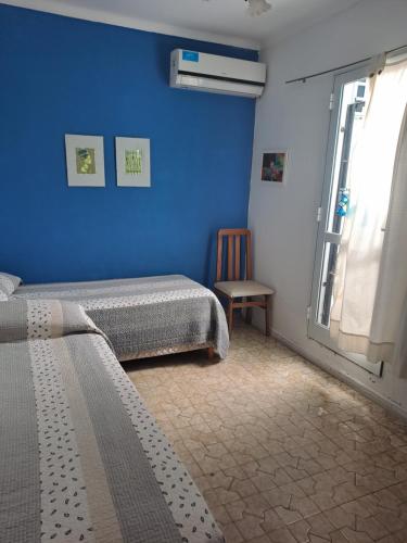 1 dormitorio con 2 camas y pared azul en El cerezo en Tandil