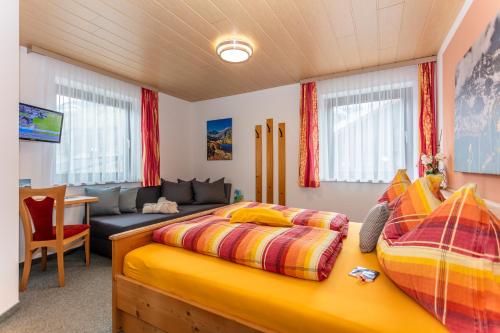 um quarto com 2 camas e um sofá em Frühstücks- Pension Sonnblickhof em Rauris