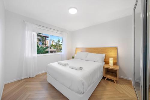 Un dormitorio blanco con una cama grande y una ventana en Newly Renovated Unit in Southport Gold Coast en Gold Coast