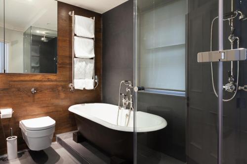 ein Badezimmer mit einer Badewanne, einem WC und einem Waschbecken in der Unterkunft The Chesterfield Suite in London