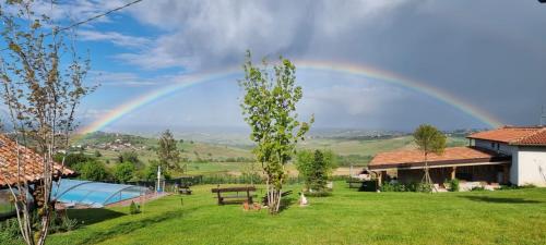 um arco-íris no céu sobre um campo verde em CASA VACANZA CON PISCINA,AREA GIOCHI BAMBINI. em Santa Maria della Versa