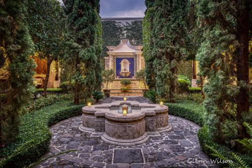 un jardín con una fuente frente a una casa en San Rafael Hotel, en Antigua Guatemala