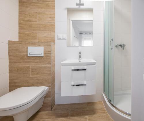 a bathroom with a toilet and a sink and a shower at Family Homes - Sand Apartments in Władysławowo