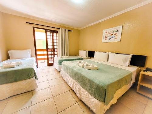 um quarto de hotel com duas camas e uma janela em Estação do Sol Praia Hotel em Porto de Galinhas