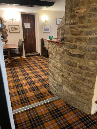 a living room with a stone wall and a table at The Dog & Partridge Country Inn in Ashbourne
